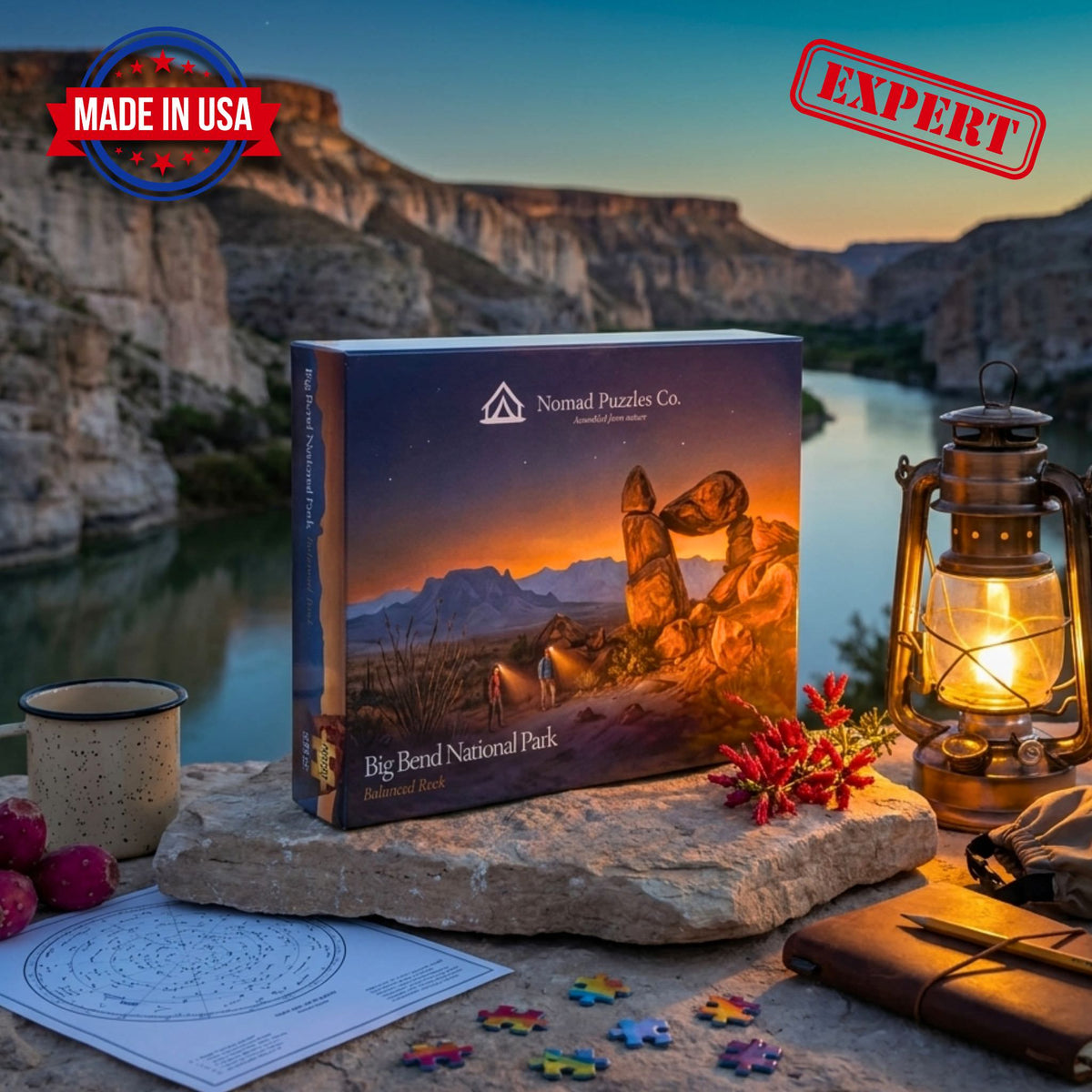 Nomad Puzzles Co. Big Bend Balanced Rock 1,000-piece puzzle box on a boulder at twilight, with a brass lantern, star chart, and loose puzzle pieces